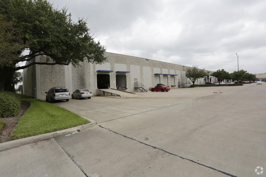 Flex-industrial building exterior — grey pebbledash warehouse with blue dock-door awnings and loading ramp, Park 10 Business Center 16820 Barker Springs Rd