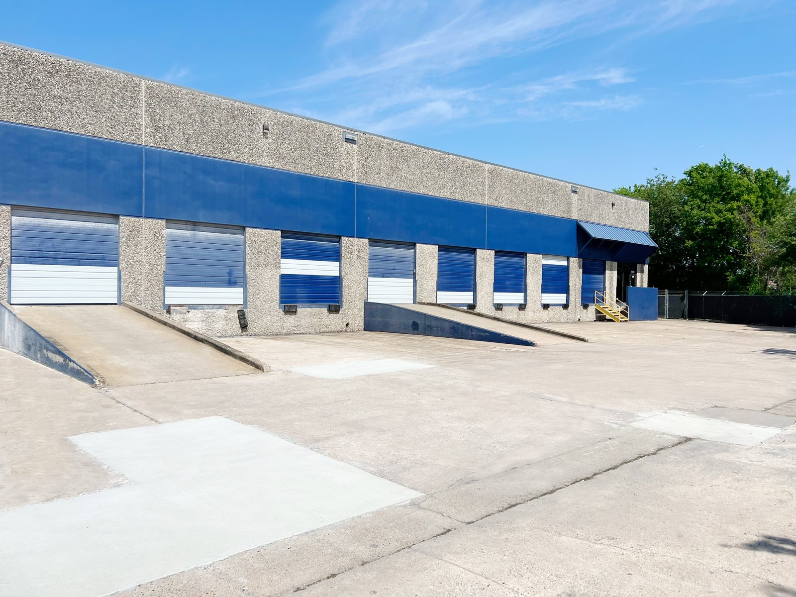 Warehouse exterior — loading dock wall with ramps, Long Point Business Center Ste 304